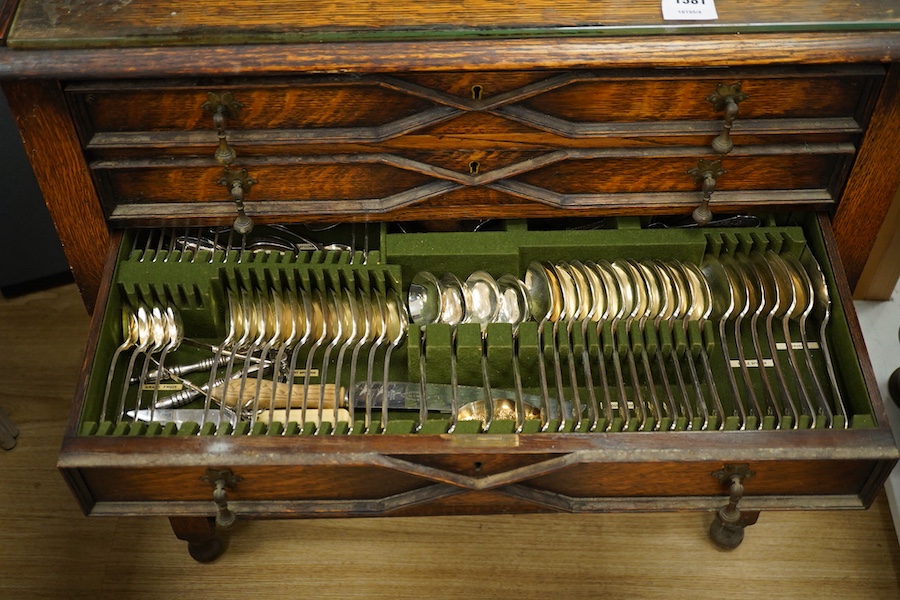A 1920’s canteen of Old English pattern flatware, housed in a Queen Anne style oak cabinet, 87cm high